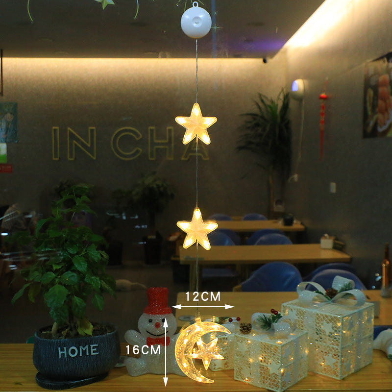 Three warm-white Christmas pendants glowing in window