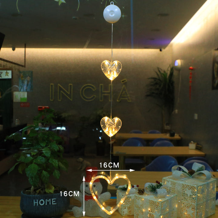 Three warm-white Christmas pendants glowing in window