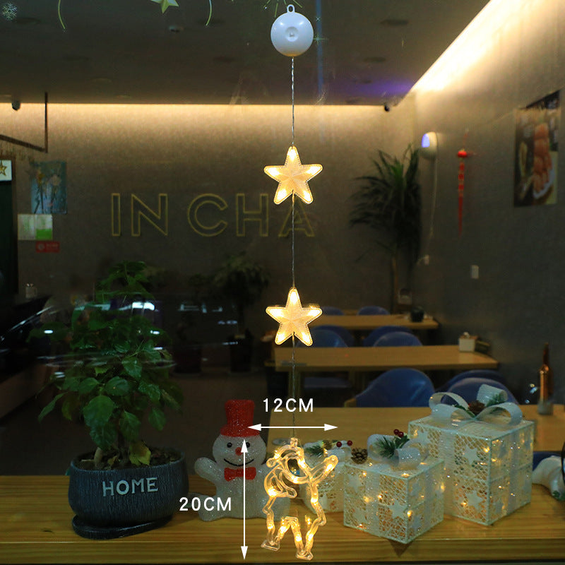 Three warm-white Christmas pendants glowing in window