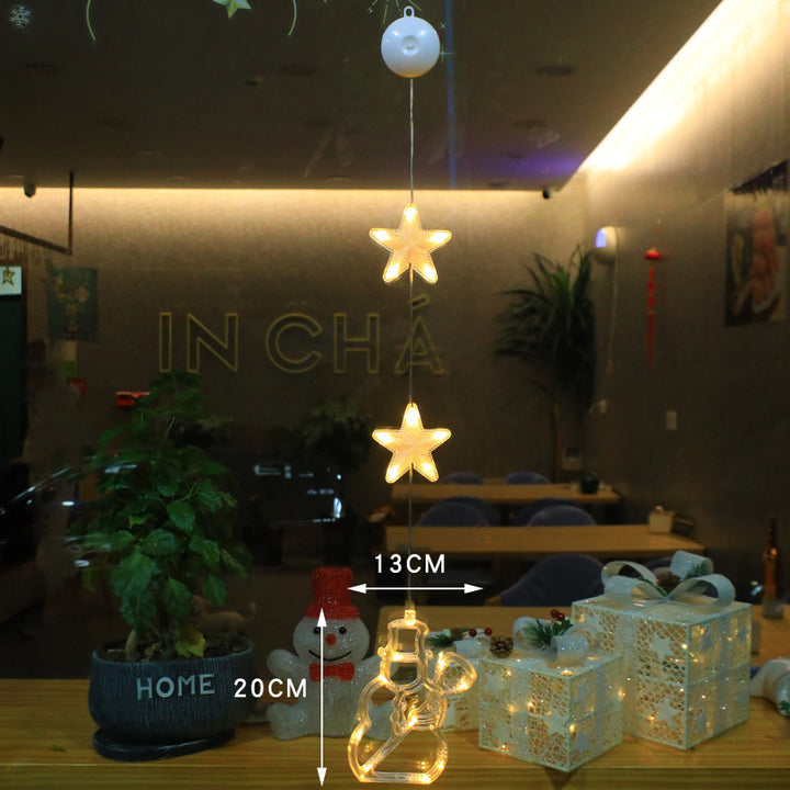 Three warm-white Christmas pendants glowing in window