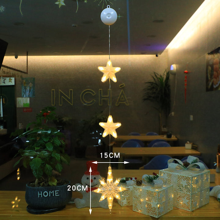 Three warm-white Christmas pendants glowing in window
