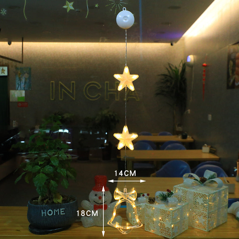 Three warm-white Christmas pendants glowing in window